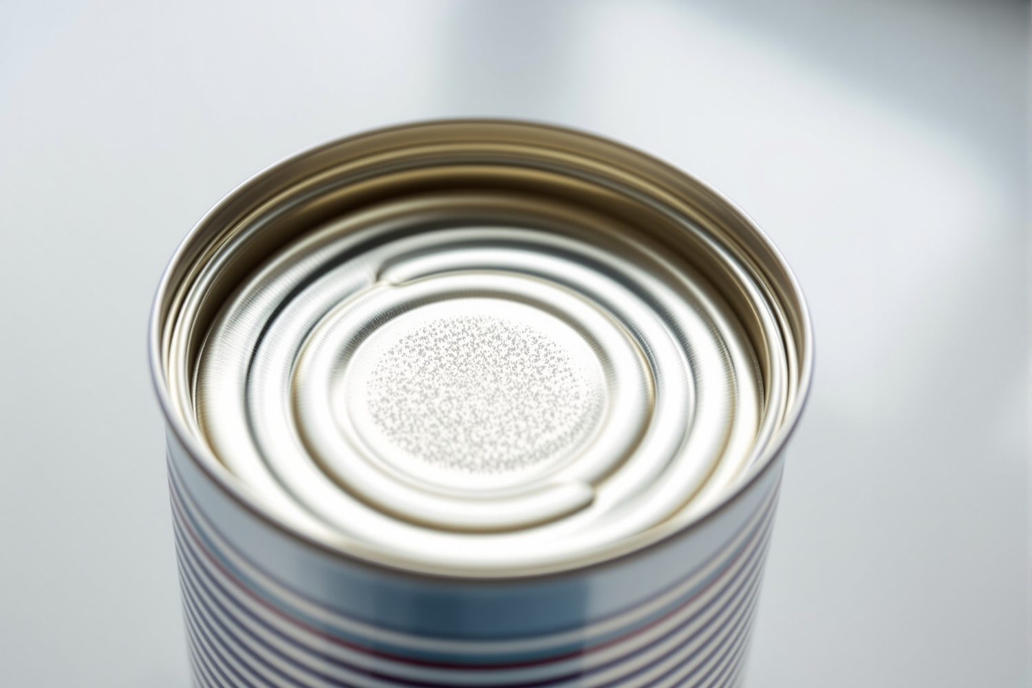 The top of a sealed metal food can showing the golden-tinted plastic epoxy coating typical of a can's interior lining