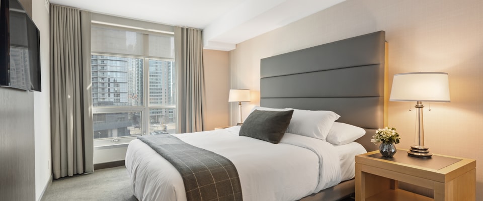 Clean, naturally lit bedroom with white organic linen bedding — a calm, safe sleep environment