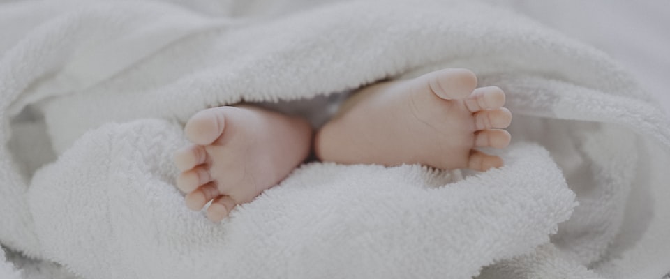 Peaceful, softly lit nursery with wooden furniture and natural textiles — a safe space for a baby