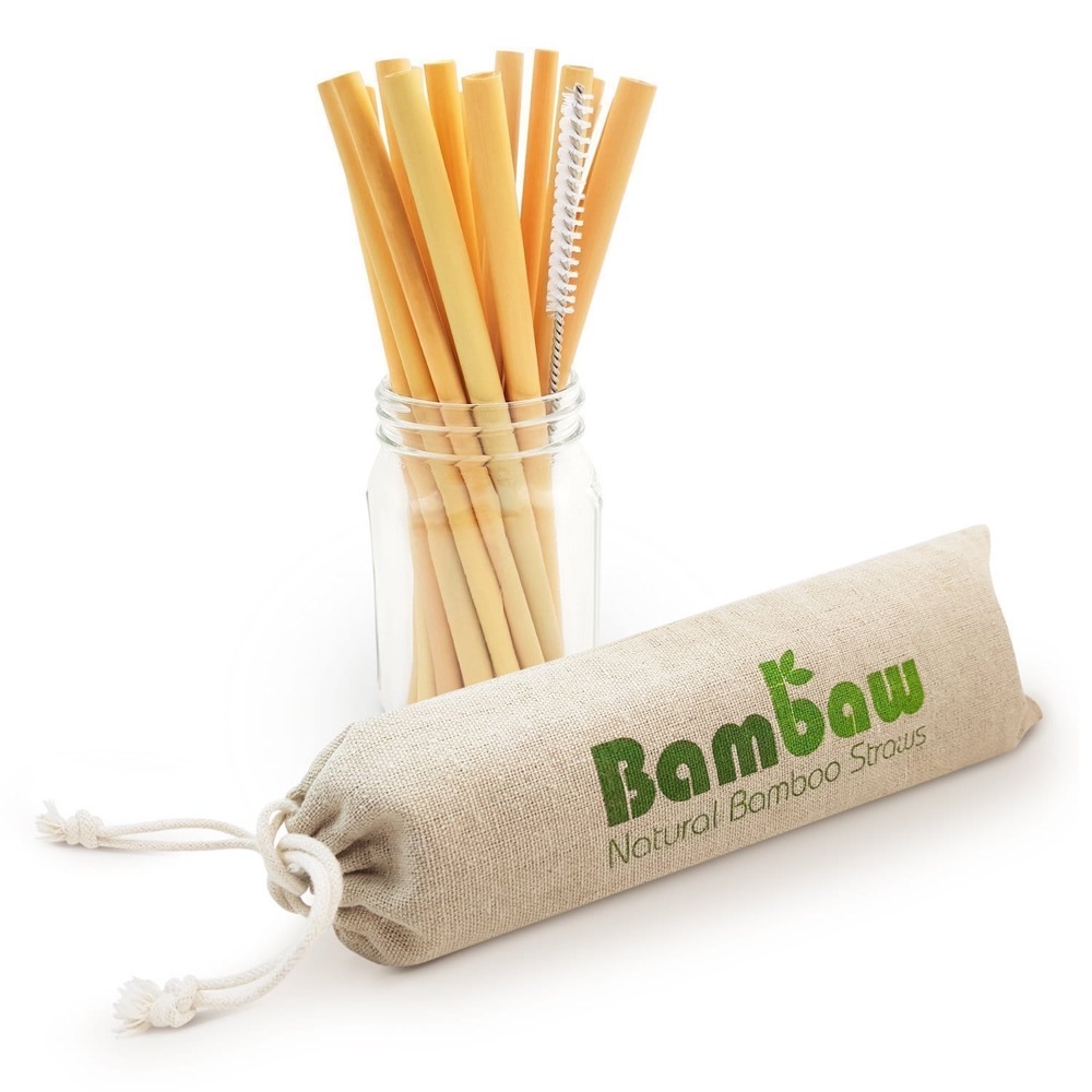 Bambaw natural bamboo straws standing in a glass jar with a cleaning brush and branded linen pouch