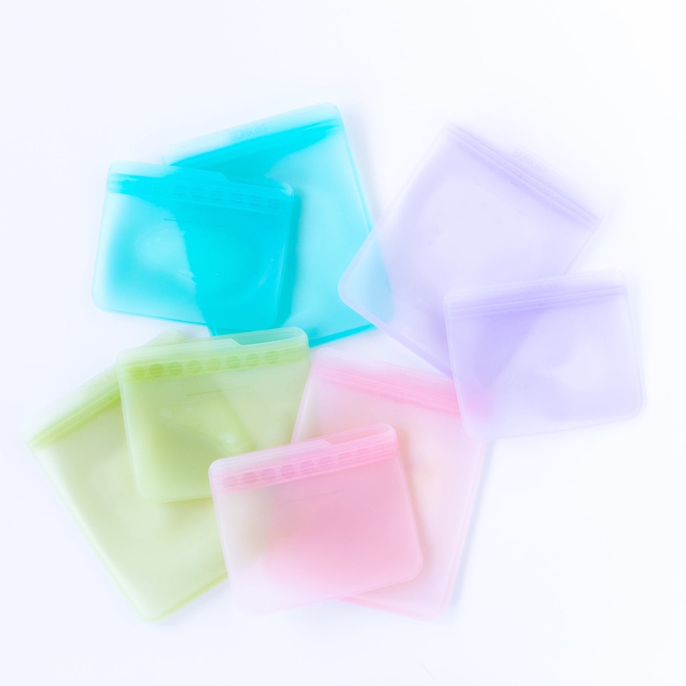 Bumkins silicone reusable bags in teal, lavender, green and pink with child-safe seal-loc closure — 100% platinum LFGB silicone, leak-resistant, toddler-friendly