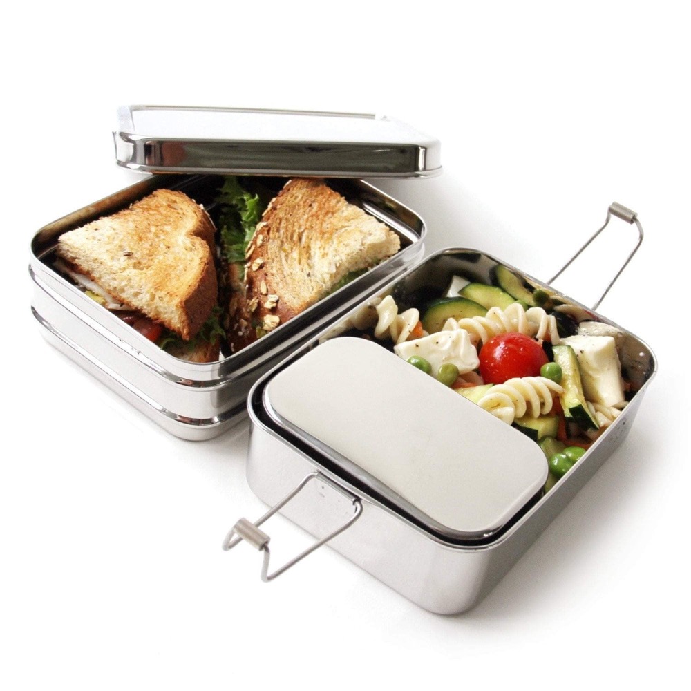 ECOlunchbox Three-in-One stainless steel bento — nesting plastic-free lunch containers with wire clasps, holding a sandwich and pasta salad