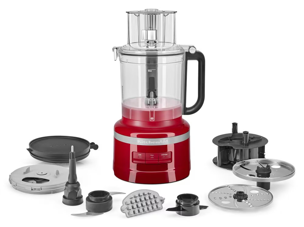 KitchenAid 13-cup food processor in empire red with its clear work bowl, slicing and shredding discs, and dicing kit