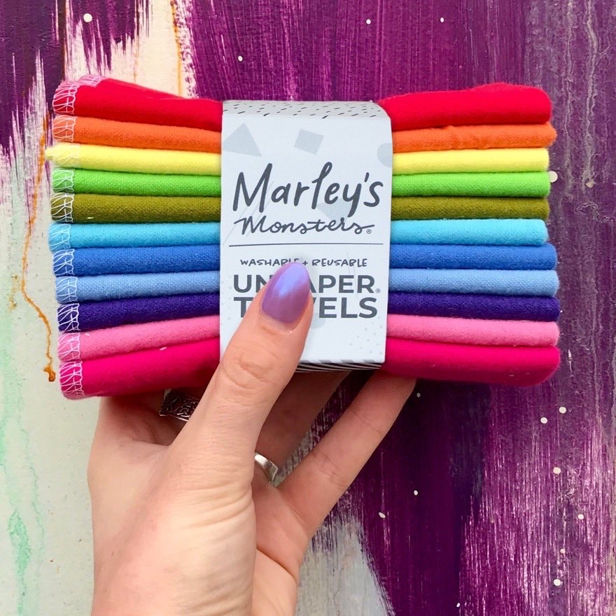 Marley's Monsters UNpaper Towels — a banded stack of rainbow organic cotton flannel reusable paper towels held in one hand