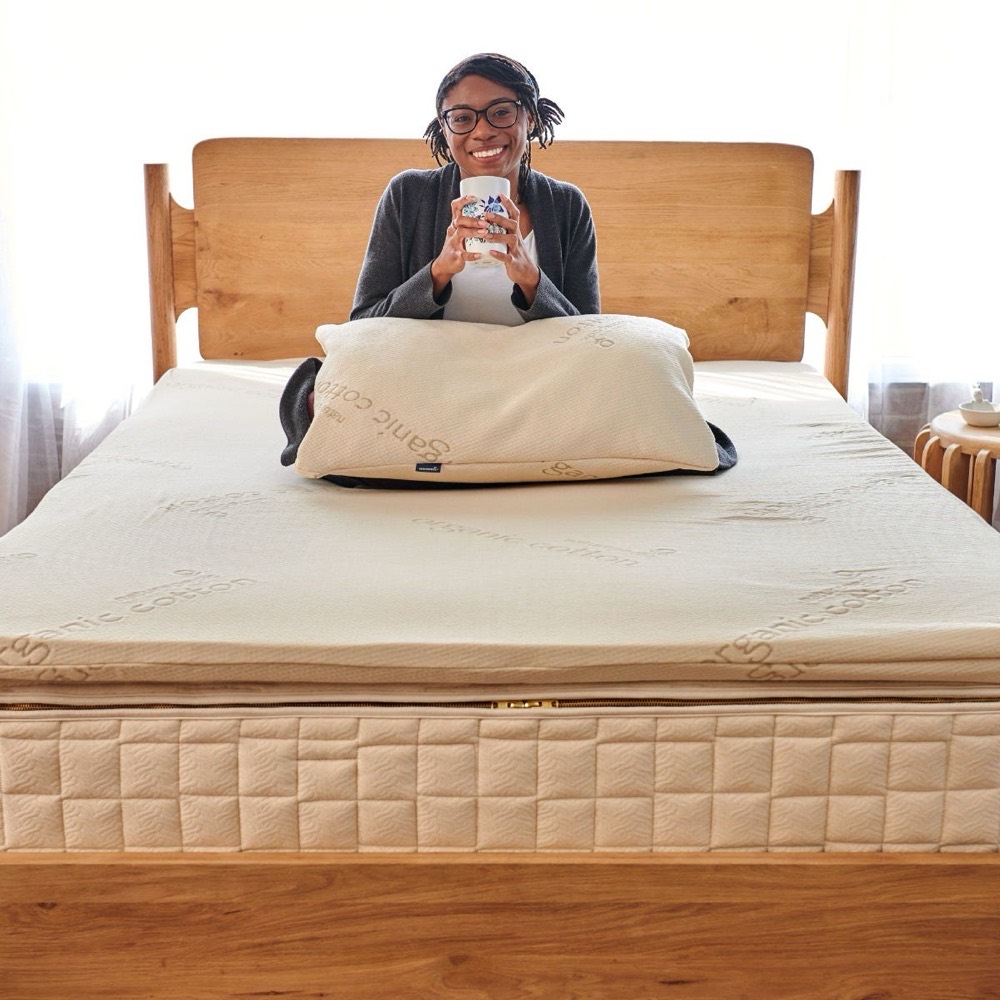 Naturepedic Organic Latex Topper — GOTS and GOLS dual-certified organic latex with an organic cotton cover on a bed