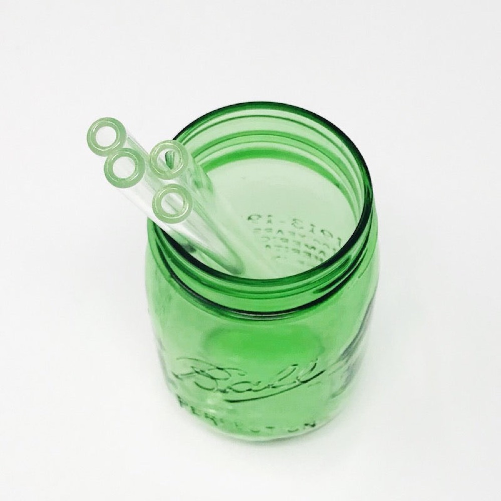 Strawesome clear hand-blown glass straws, set of four, standing in a green glass mason jar
